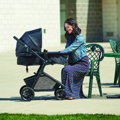 Evenflo Pivot Modular Travel System with SafeMax Car Seat, stroller with car seat attached, featuring adjustable handle and storage basket.